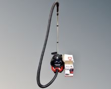 A Henry vacuum with accessories together with a box containing Henry vacuum bags.