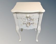 A contemporary French style two drawer bedside table with painted decoration.