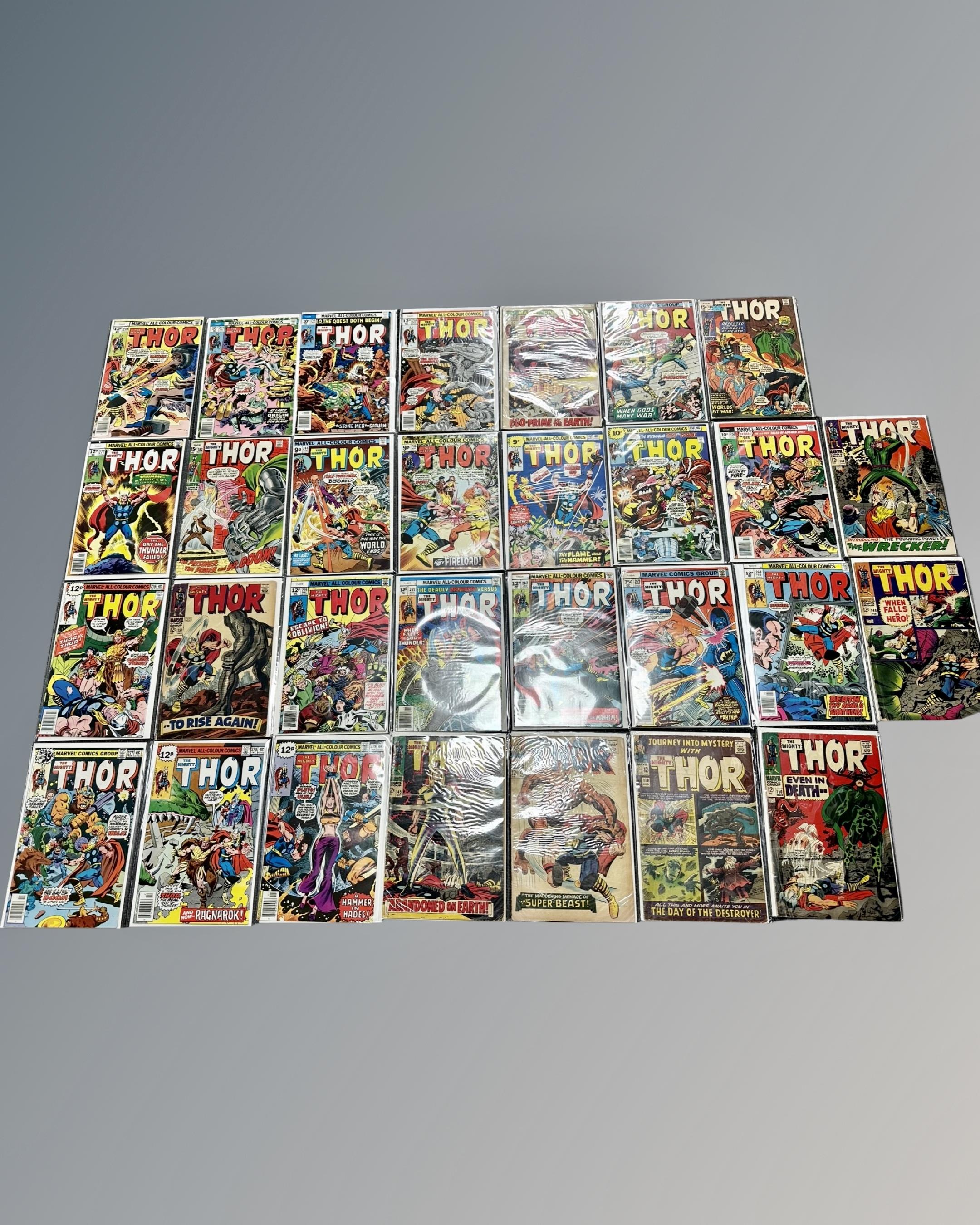 A collection of approximately 30 vintage Marvel The Mighty Thor comics, in plastic covers.