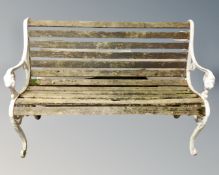 A white cast iron wooden slatted garden bench.