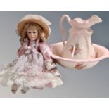 An ironstone pink floral patterned wash jug and basin together with a porcelain headed doll.