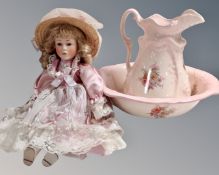 An ironstone pink floral patterned wash jug and basin together with a porcelain headed doll.