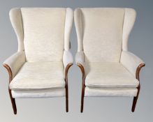 A pair of 20th century beech framed wing backed fireside chairs.