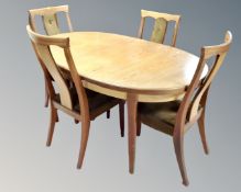 A 20th century teak G plan oval extending dining table and four chairs.