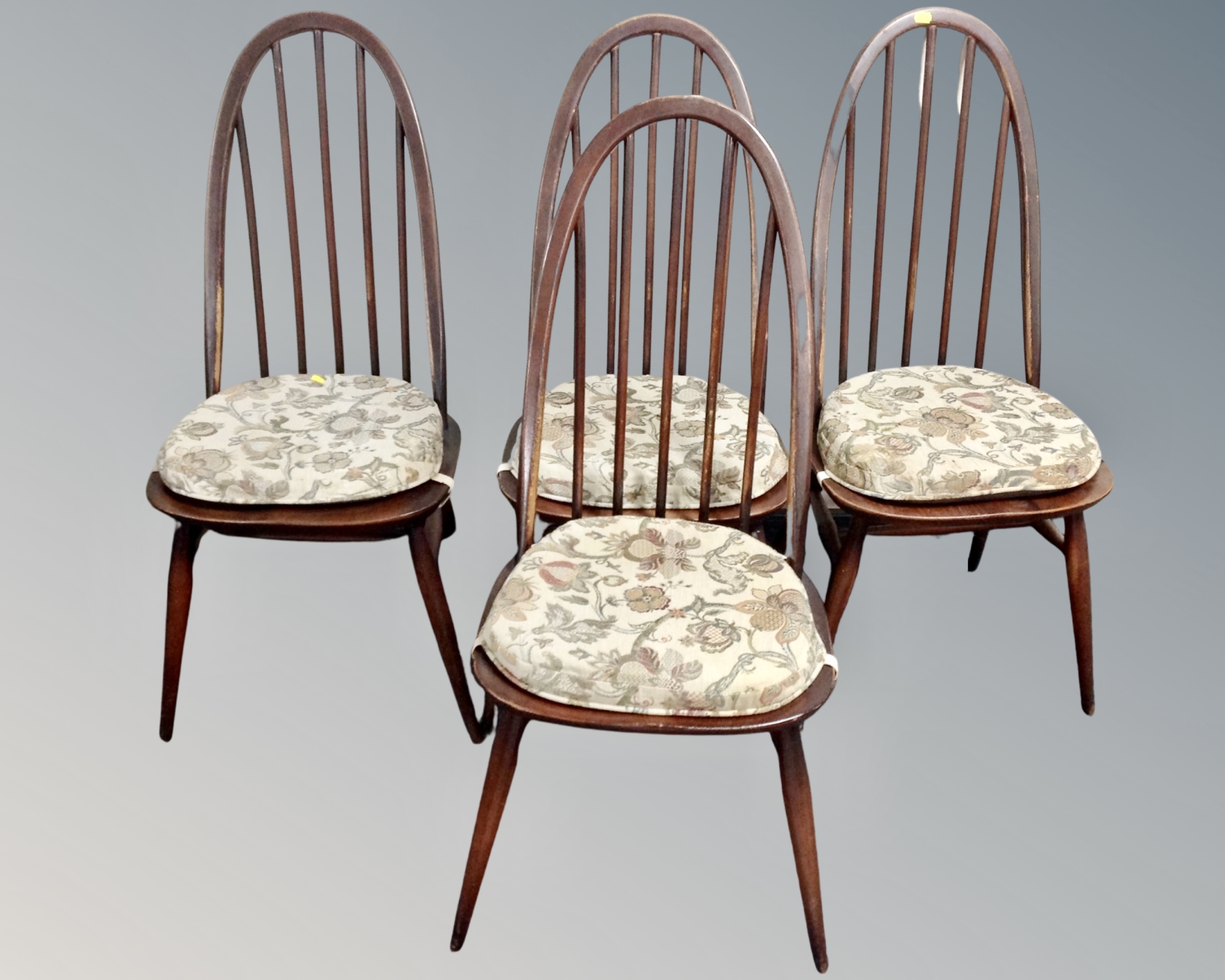 A set of four Ercol stained elm and beech stick back dining chairs