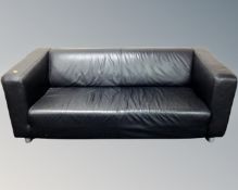 A pair of contemporary black leather settees on metal legs.