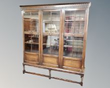 An Edwardian oak triple door bookcase on barley twist stand.