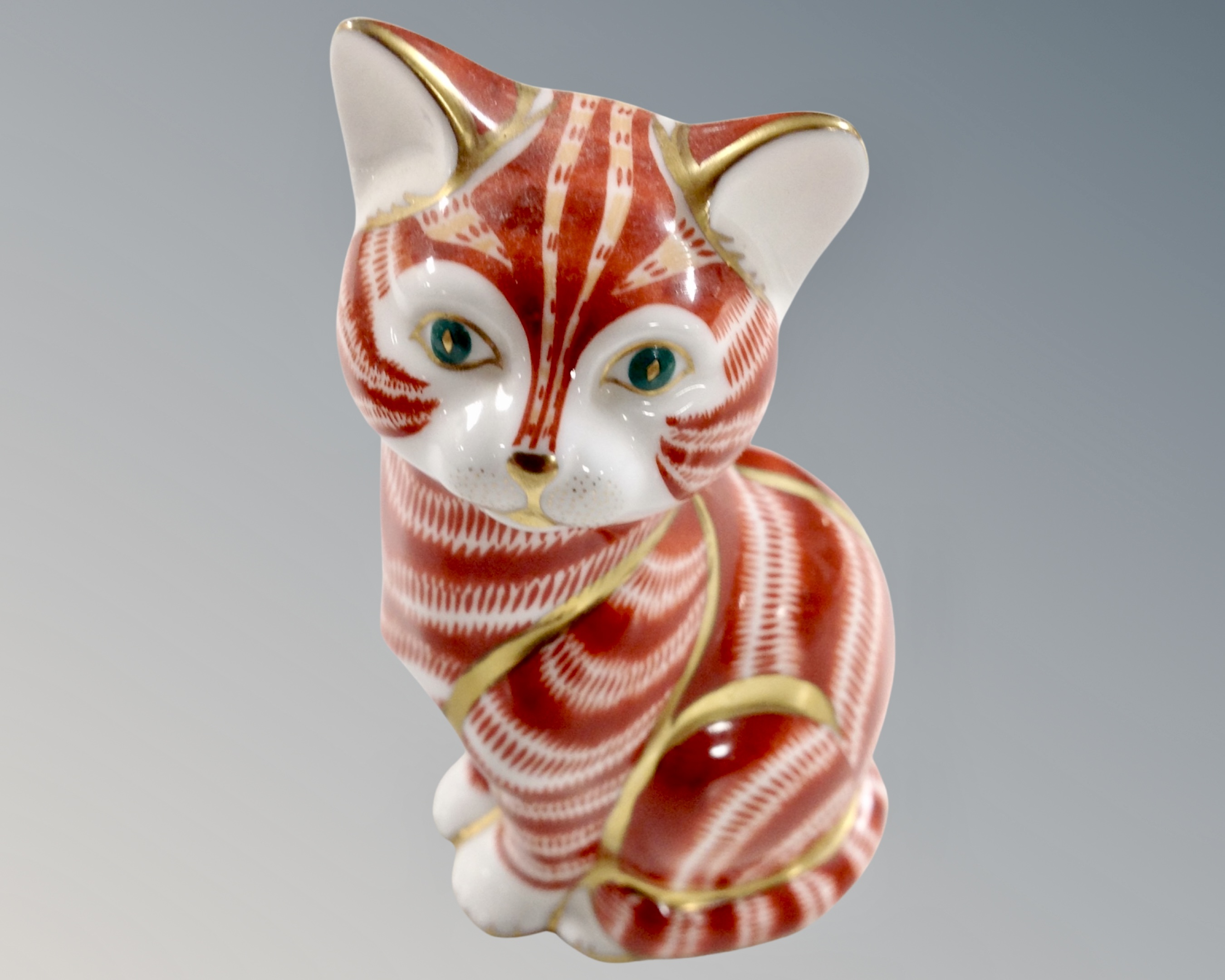 A Royal Crown Derby seated cat paperweight with silver stopper.