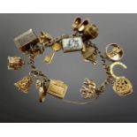 A 9ct gold charm bracelet with seventeen 9ct gold charms, 50.9g.