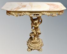 An ornate gilt and onyx topped console table on cherub pedestal support.