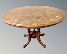 A Victorian oval inlaid walnut occasional table on a carved base.