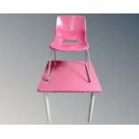 A square pink topped dining table on metal legs together with matching chair.