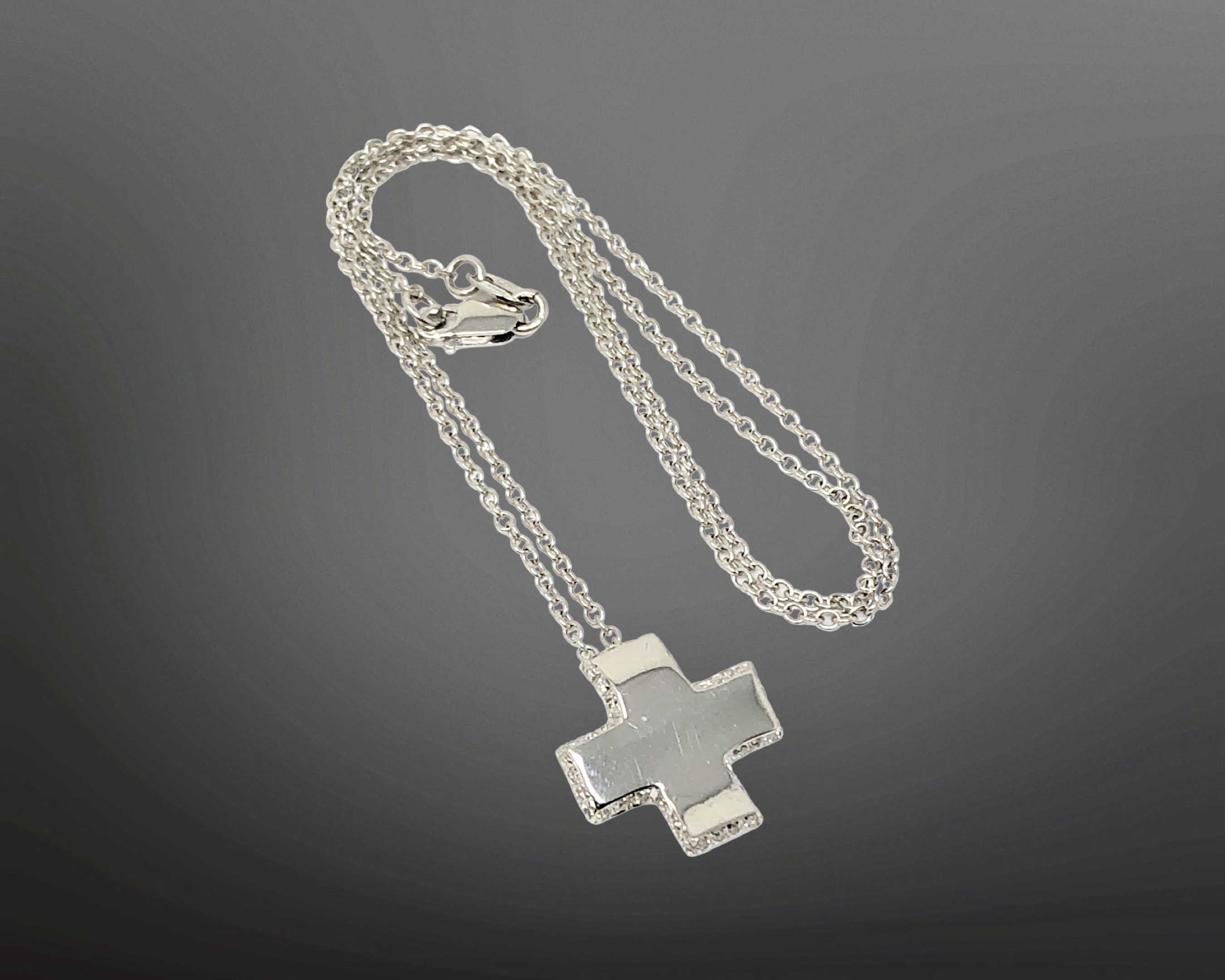 An 18ct white gold diamond set cross pendant on chain CONDITION REPORT: 4.