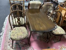 An Ercol stained elm and beech drop leaf table together with a set of four Fleur de Lys dining