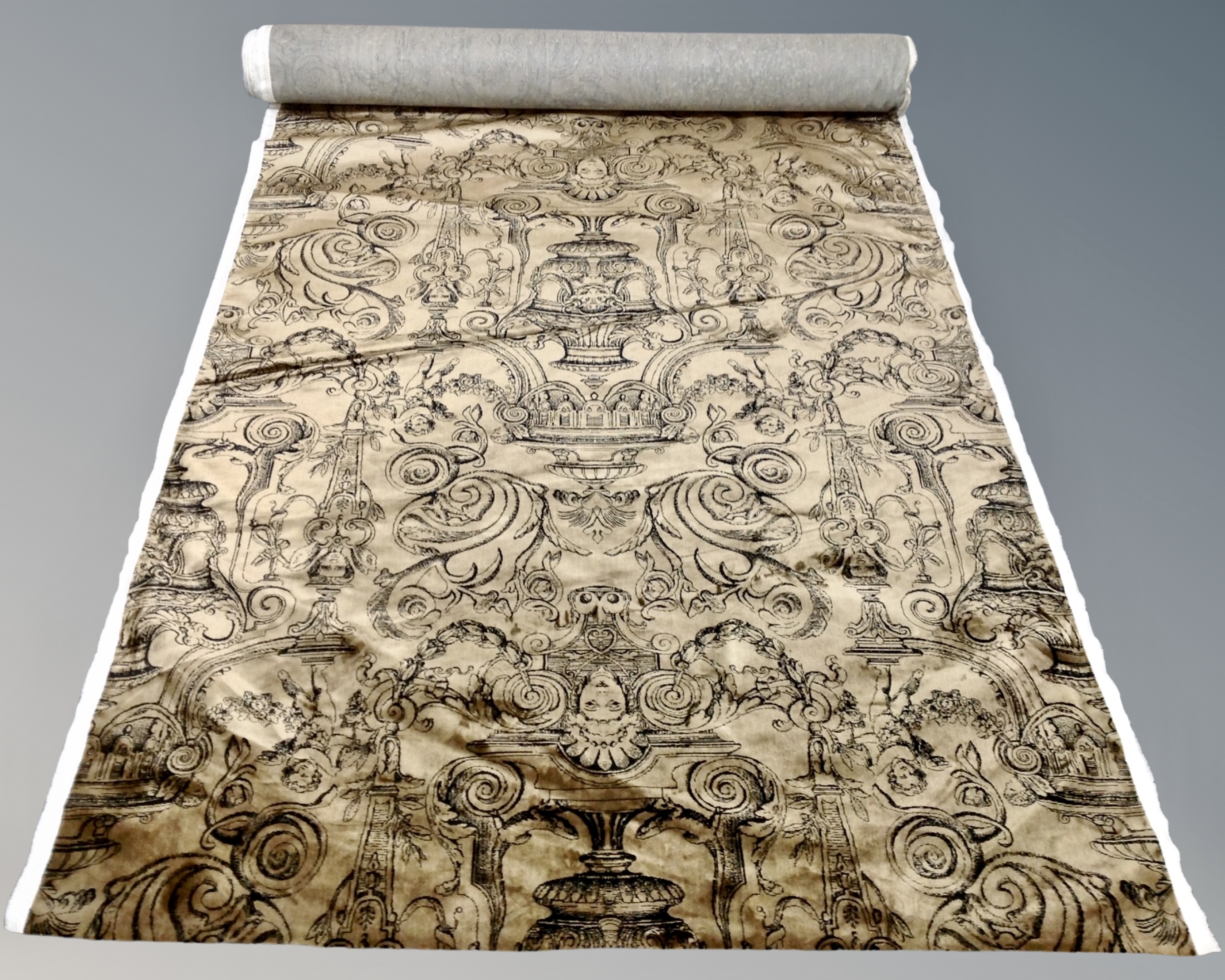 A roll of brown velvet fabric with classical motif.