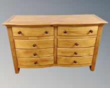 A contemporary pine bow fronted eight drawer chest together with a pair of matching two drawer