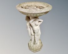 A concrete Three Graces birdbath.