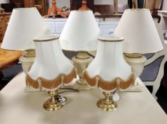 Three ceramic cream and gilt table lamps with shades together with a further pair of brass table