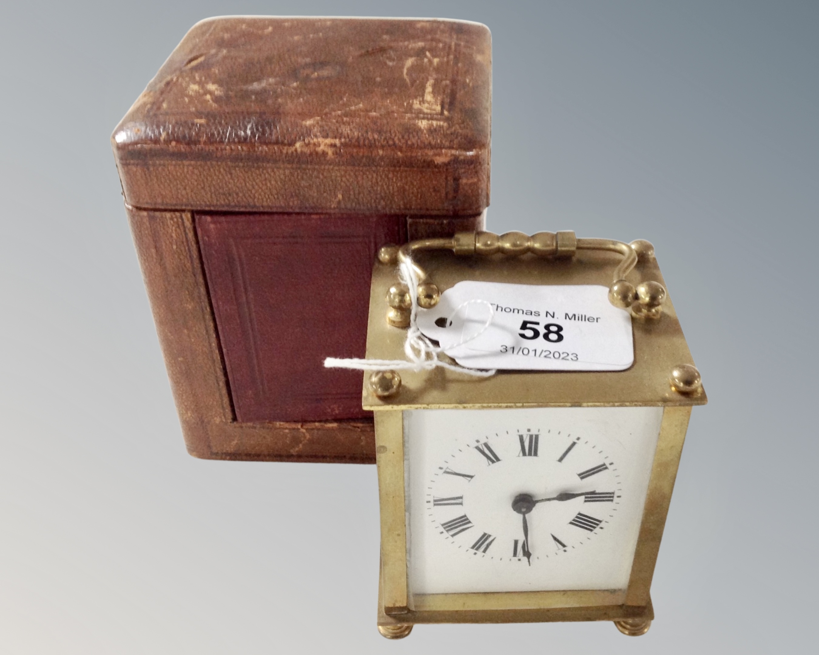 An antique brass carriage clock, with key in leather case.