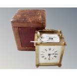 An antique brass carriage clock, with key in leather case.