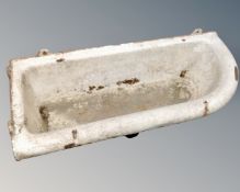 An antique cast iron wall mounted trough.