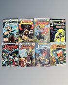 A collection of eight vintage DC The Shadow comics, some in plastic covers.