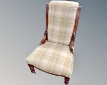 A Victorian nursing chair upholstered in a tartan fabric.