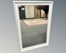 A contemporary white bevelled mirror, 61cm by 88cm.