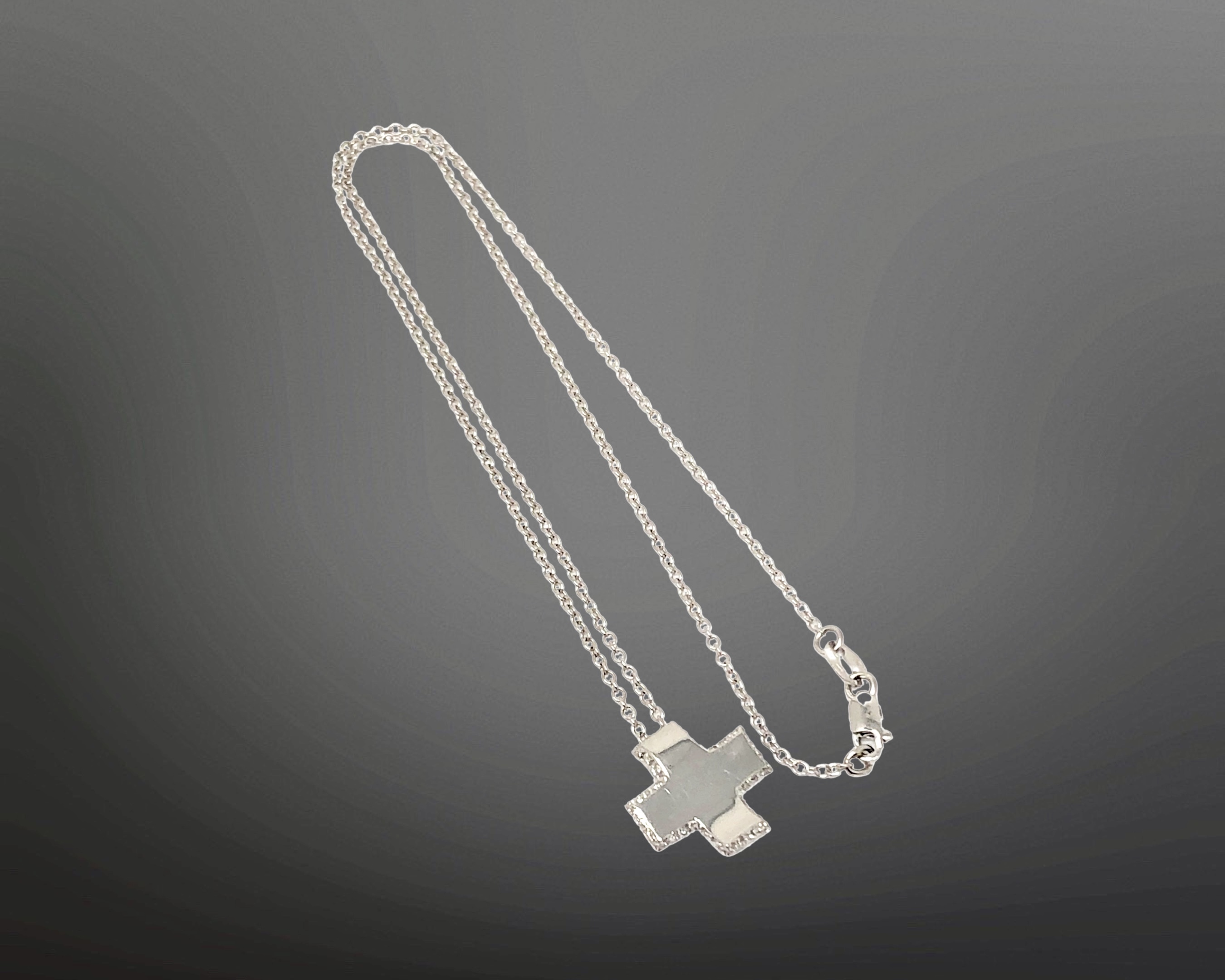 An 18ct white gold diamond set cross pendant on chain CONDITION REPORT: 4.