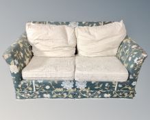 A two seater bed settee upholstered in a floral fabric.