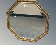 An octagonal bevelled mirror in gilt frame, 56cm by 56cm.