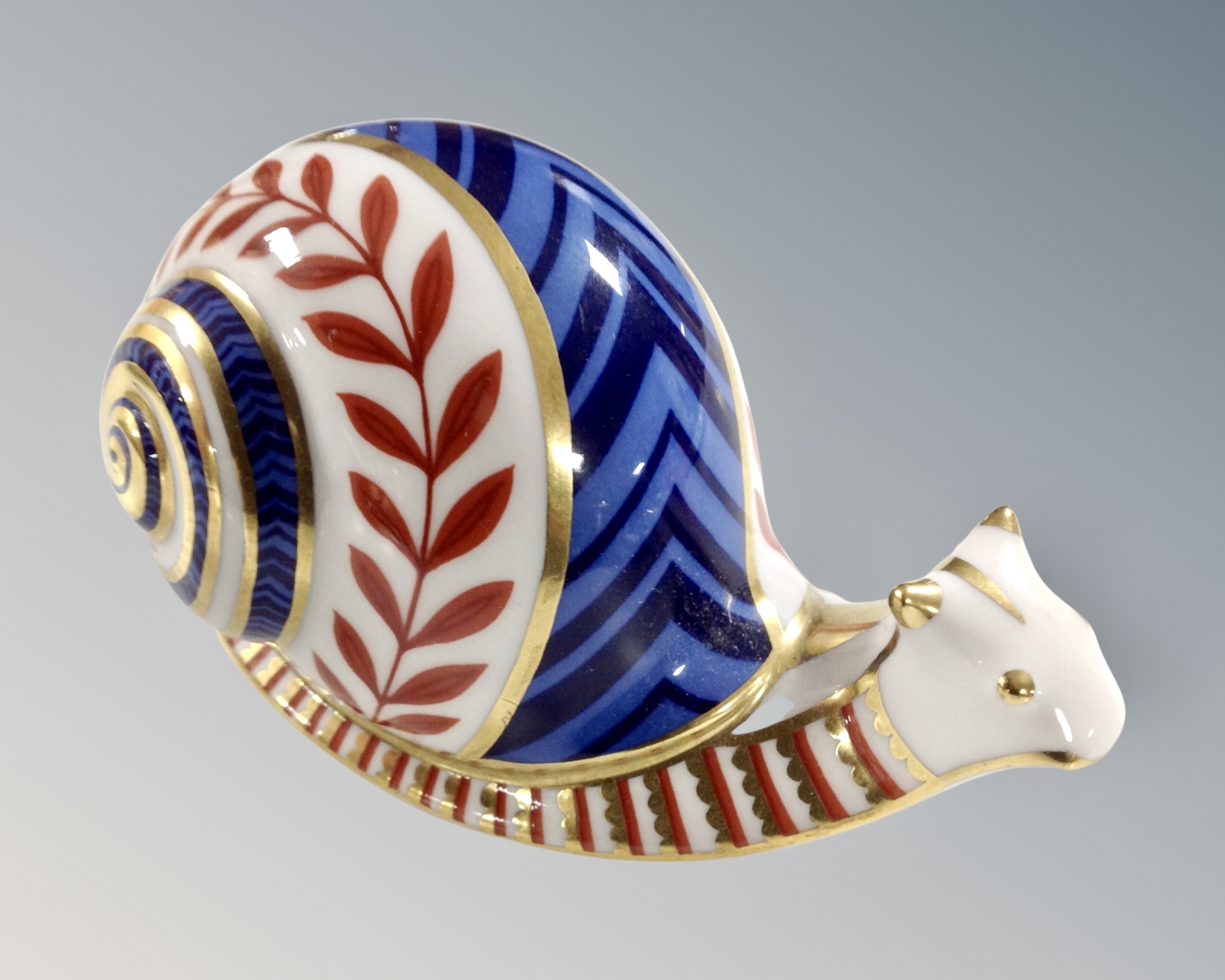 A Royal Crown Derby snail paperweight with porcelain stopper.