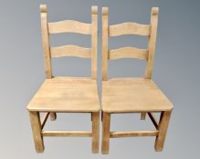 A pair of contemporary pine farmhouse dining chairs.