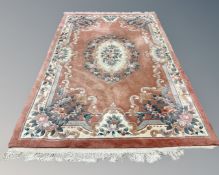 A Chinese carpet on peach ground, 183cm by 275cm.