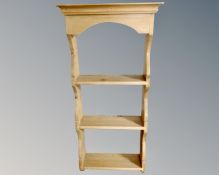 A narrow pine three tier wall shelf.