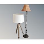 A contemporary floor lamp on tripod base together with a further floor lamp with wicker shade.