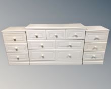 A white Alstons furniture seven drawer chest together with a pair of matching three drawer bedside