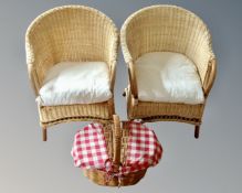 A pair of wicker armchairs together with a hamper.