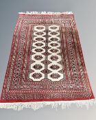 An Afghan Tekke rug on red and cream ground,