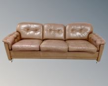 A 1970s Scandinavian brown button leather three seater settee.