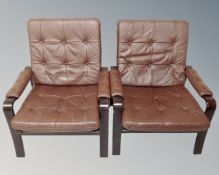 A pair of Scandinavian beech framed armchairs in brown studded leather
