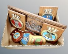 A box of painted crests mounted on wooden shields,