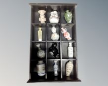 A wooden display case containing twelve assorted Japanese porcelain vases