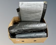 A box containing a quantity of tarpaulins.