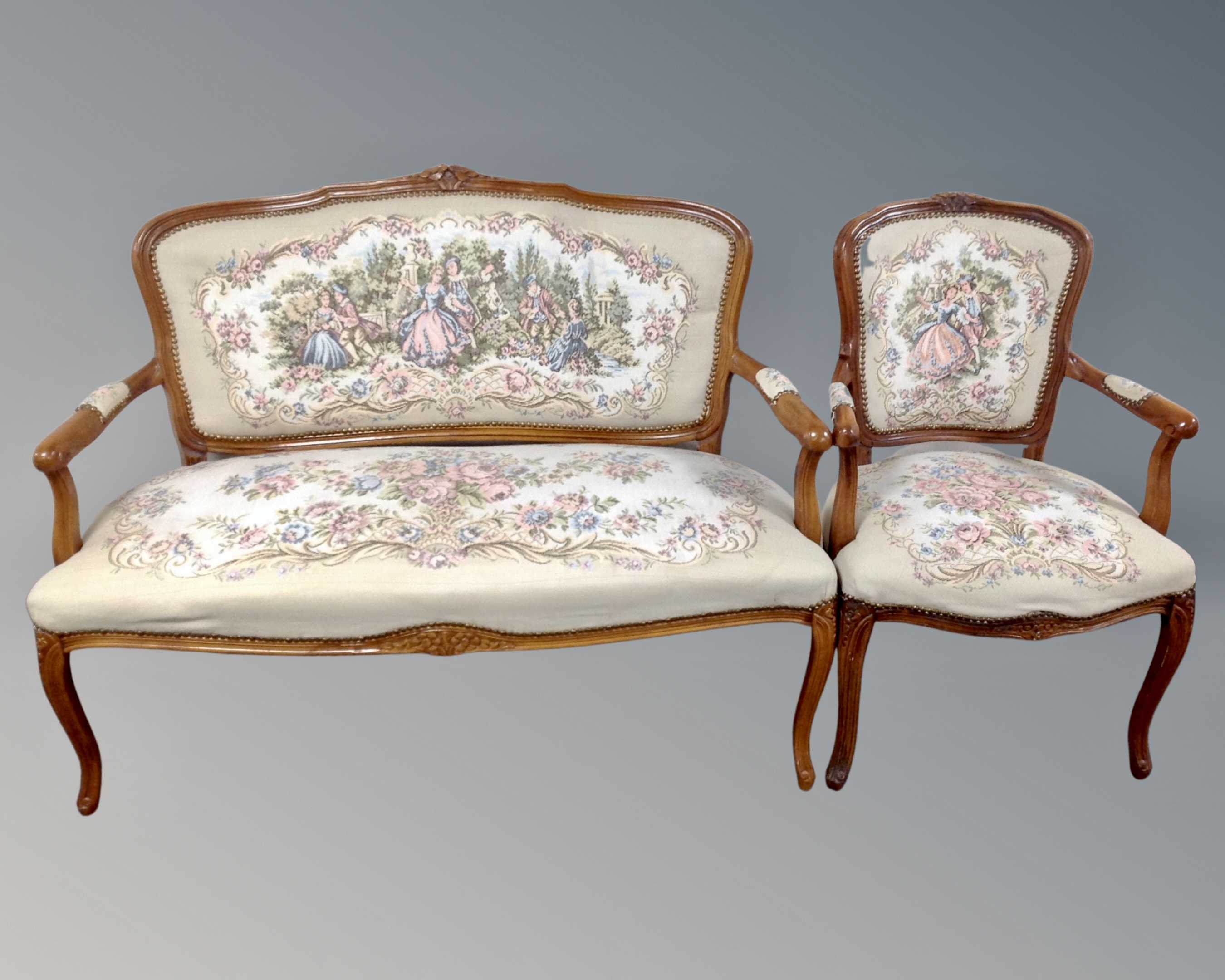 A French style carved beech salon settee and matching open armchair in floral upholstery.