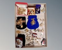 A tray of costume jewellery, brooches, key rings,