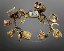 A 9ct gold charm bracelet with seventeen 9ct gold charms, 50.9g.