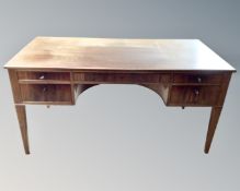 A continental beech writing desk fitted with five drawers.
