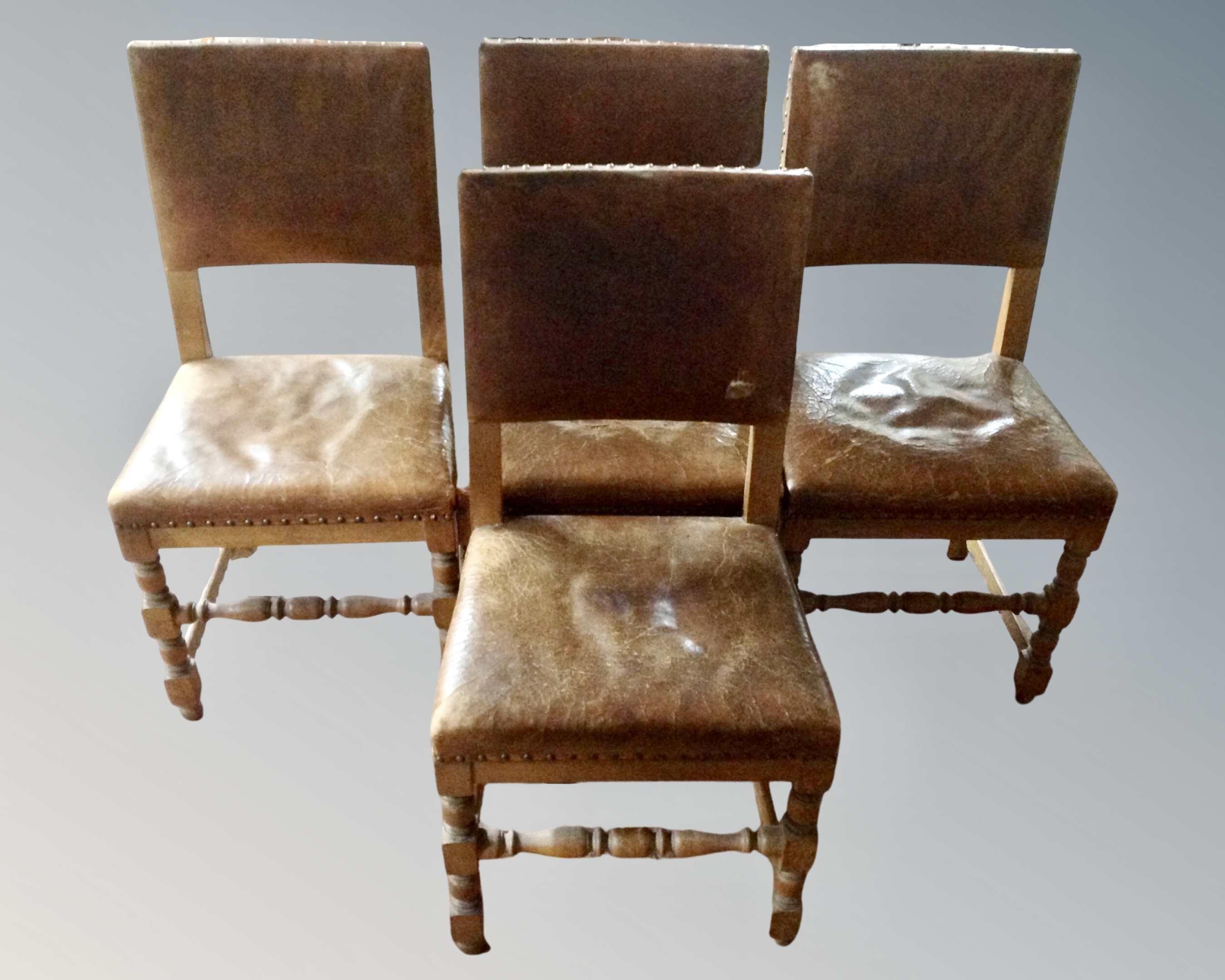 A set of four 19th century dining chairs in studded leather upholstery.