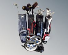 Four golf bags containing assorted clubs together with a Motocaddy.